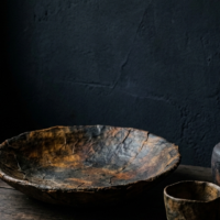 静謐な薄暗い空間に佇む、深い飴色に変化した伝統的な一閑張り行李の圧倒的な存在感