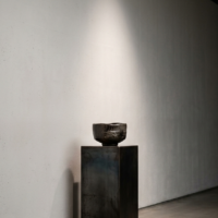 ロンドンのモダンなギャラリー空間に静かに佇む、極限にまで削ぎ落とされた日本の工芸品